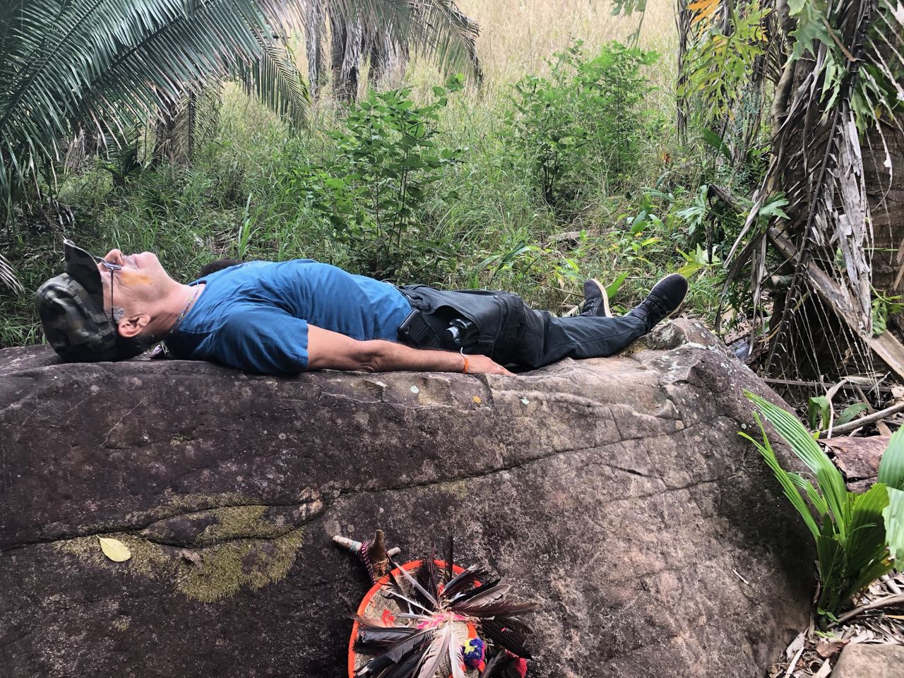 Mauricio lies on the carved boulder